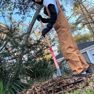 Person raking leaves outdoors in autumn.