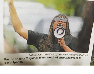 Pastor Sherita Traywick speaks passionately through a megaphone.