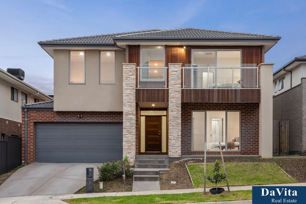 Modern two-story house with a sleek design and large windows.
