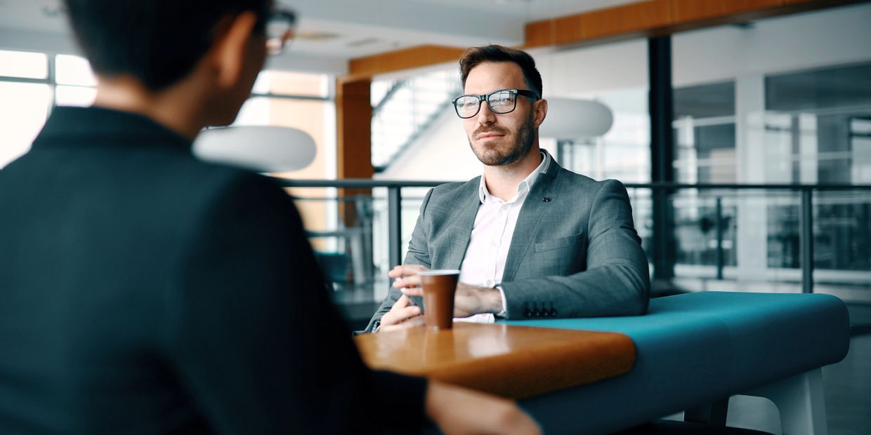 Two professionals engaged in a serious discussion in a modern office.