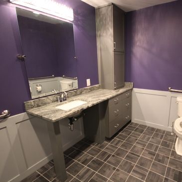 Modern purple and gray bathroom with wainscoting and tile. ADA handicap wheelchair accessible shower