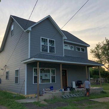 New build home. Gray vinyl siding on two story house.