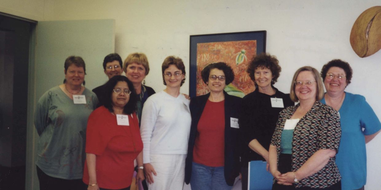A group of nine members pose together at the 2001 conference. 