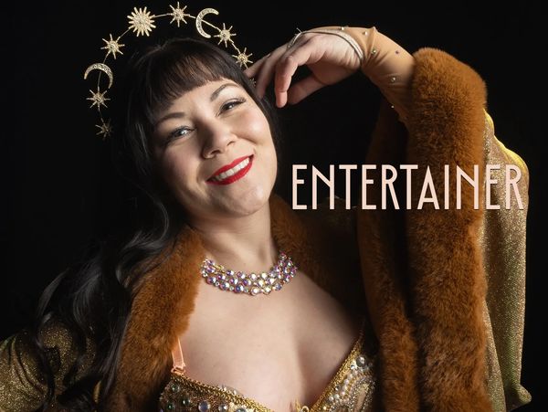 Pony smiles in a gold classic burlesque costume