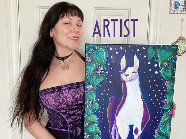 Pony holding one of her paintings and smiling