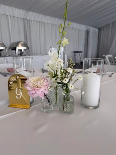 Elegant table centerpiece with flowers, candle, and table number 9.