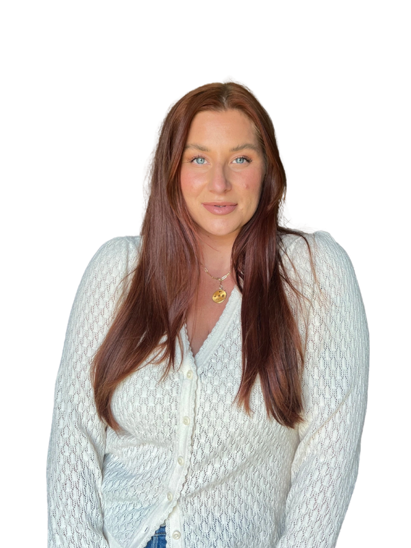 Woman with long red hair in a white knitted cardigan.