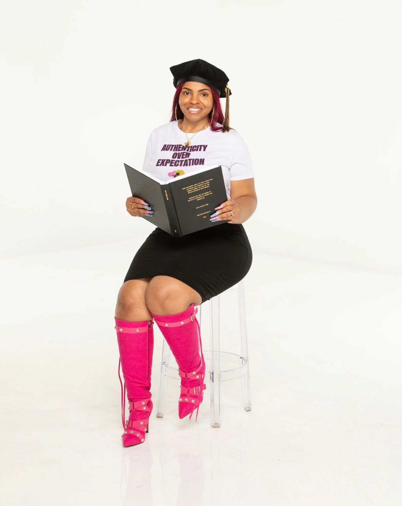 Dr. Maya Cobb PhD, LPC, ACS — therapist, author, and founder holding her dissertation.