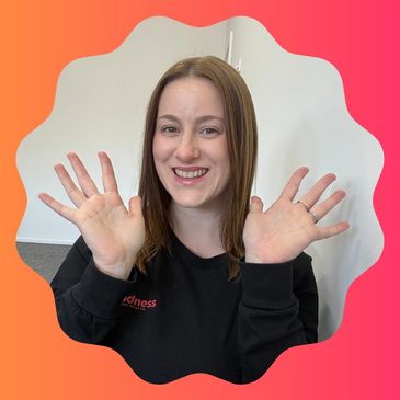 Smiling woman showing both hands raised.