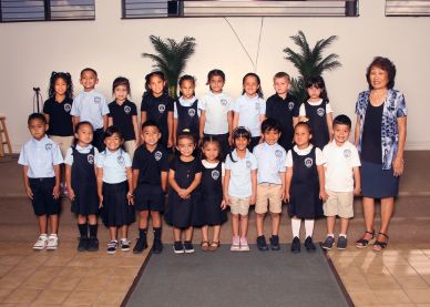 Group of young students with their teacher in a classroom.