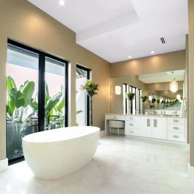 Modern bathroom with a freestanding tub and large windows.