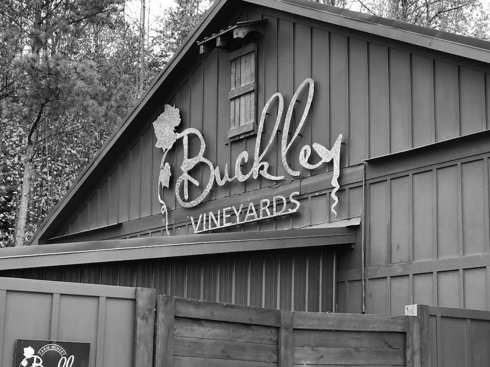Black and white image of Buckley Vineyards sign on a barn.