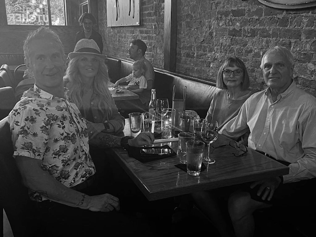 Four adults enjoying a meal together at a cozy restaurant booth.