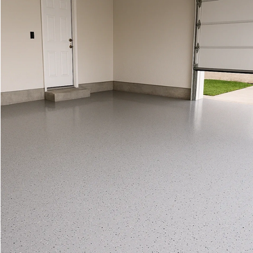Clean, polished garage floor with speckled finish and open garage door.