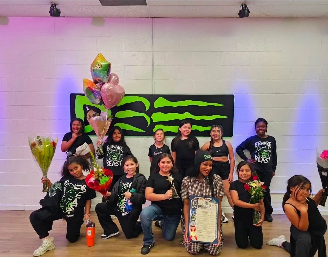 A group of girls celebrating with flowers and balloons indoors.