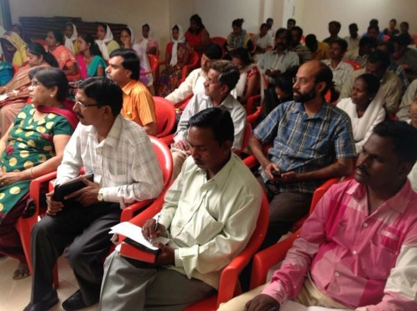 A group of people attentively listening in a meeting or seminar.