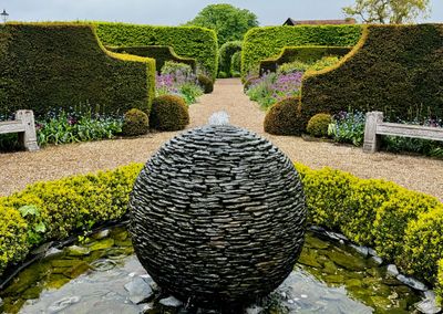 A beautiful formal garden with a stone fountain.