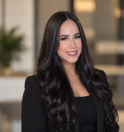 Professional woman with long dark hair and a confident smile.
