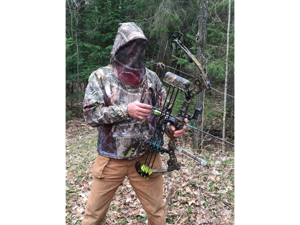 Hunter wearing Camo, mesh bug jacket while bow hunting.
