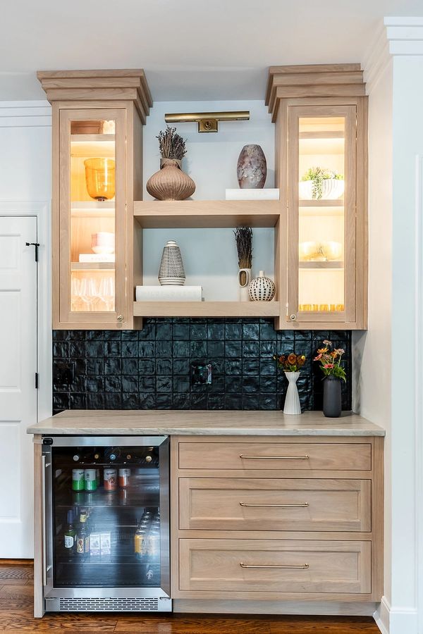 Modern kitchen nook with light wood cabinets and mini fridge.