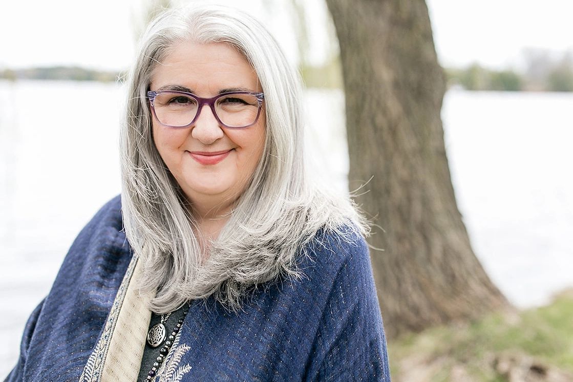 Amanda Wilson, Registered Psychotherapist in a blue wrap with water and a tree in the background