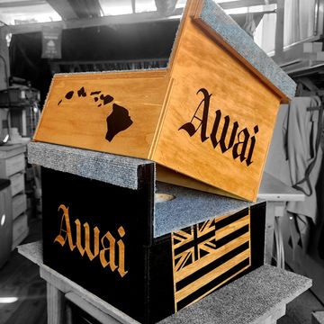 Two wooden boxes with the word 'Awai' and Hawaiian designs engraved.
