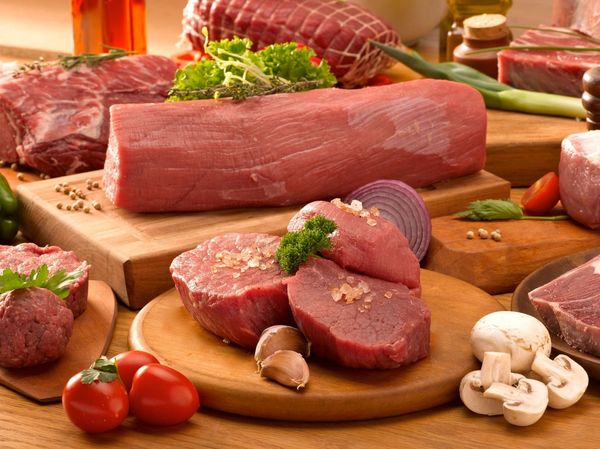 A butcher presenting a cut of beef