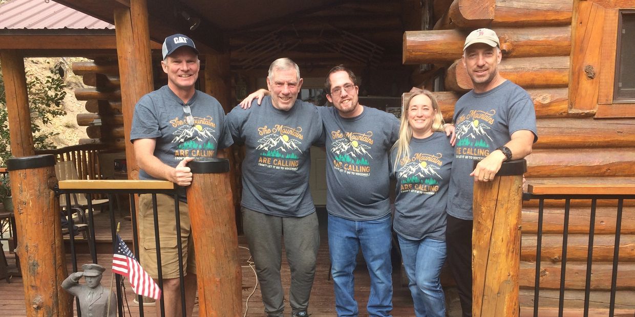 Five people standing next to each other wearing gray shirts