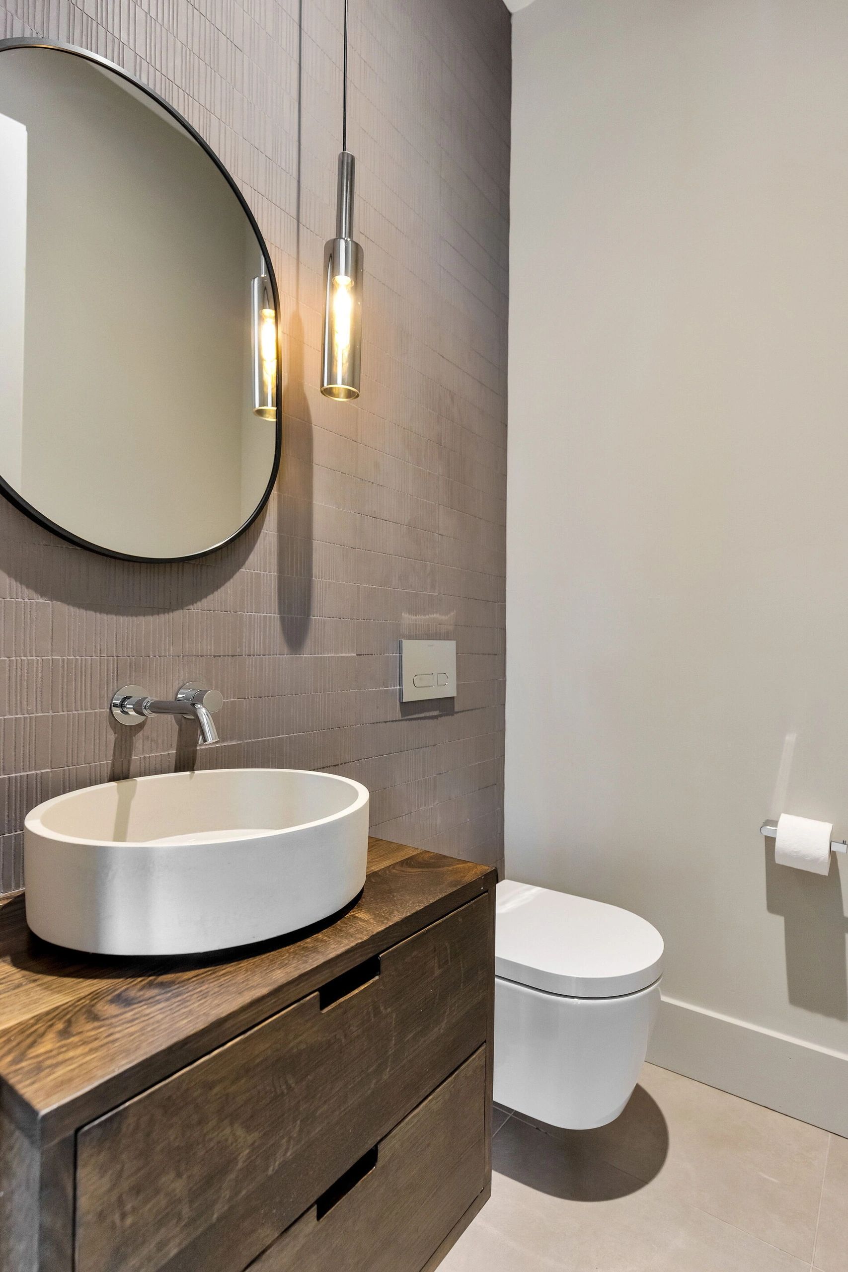 Minimalist bathroom with white sink and wooden cabinet.
