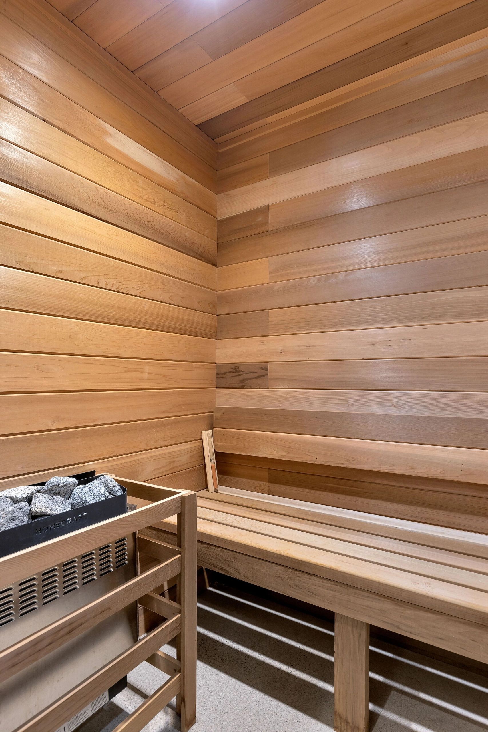 Wooden sauna interior with heater and stones.
