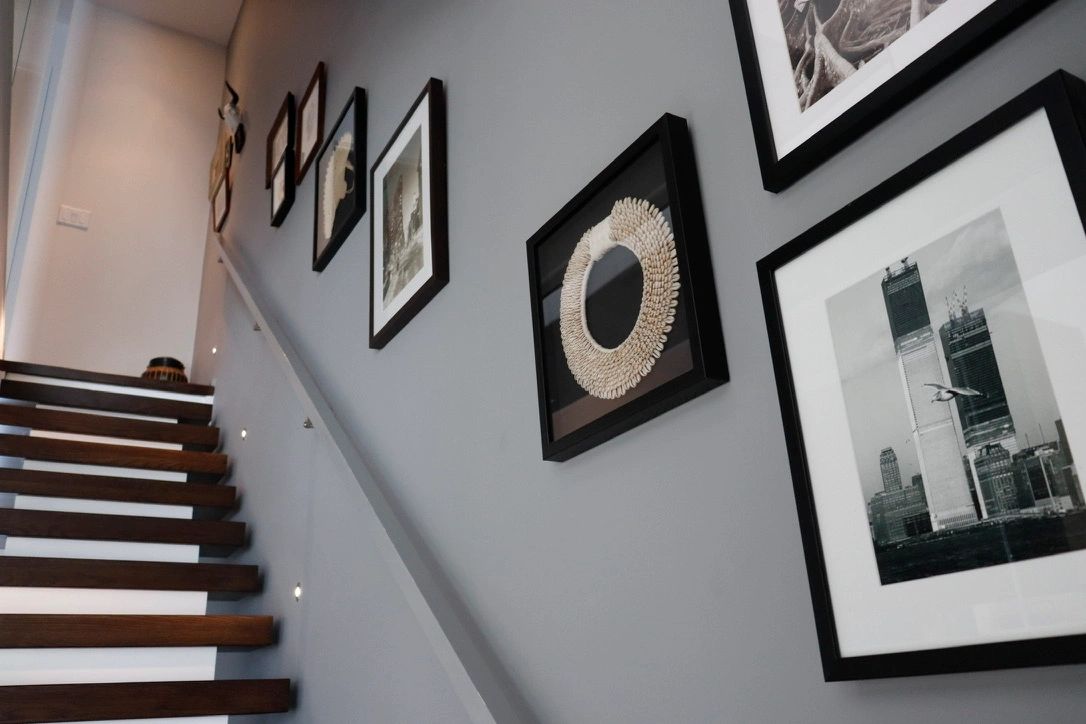Modern staircase with framed pictures on the wall.