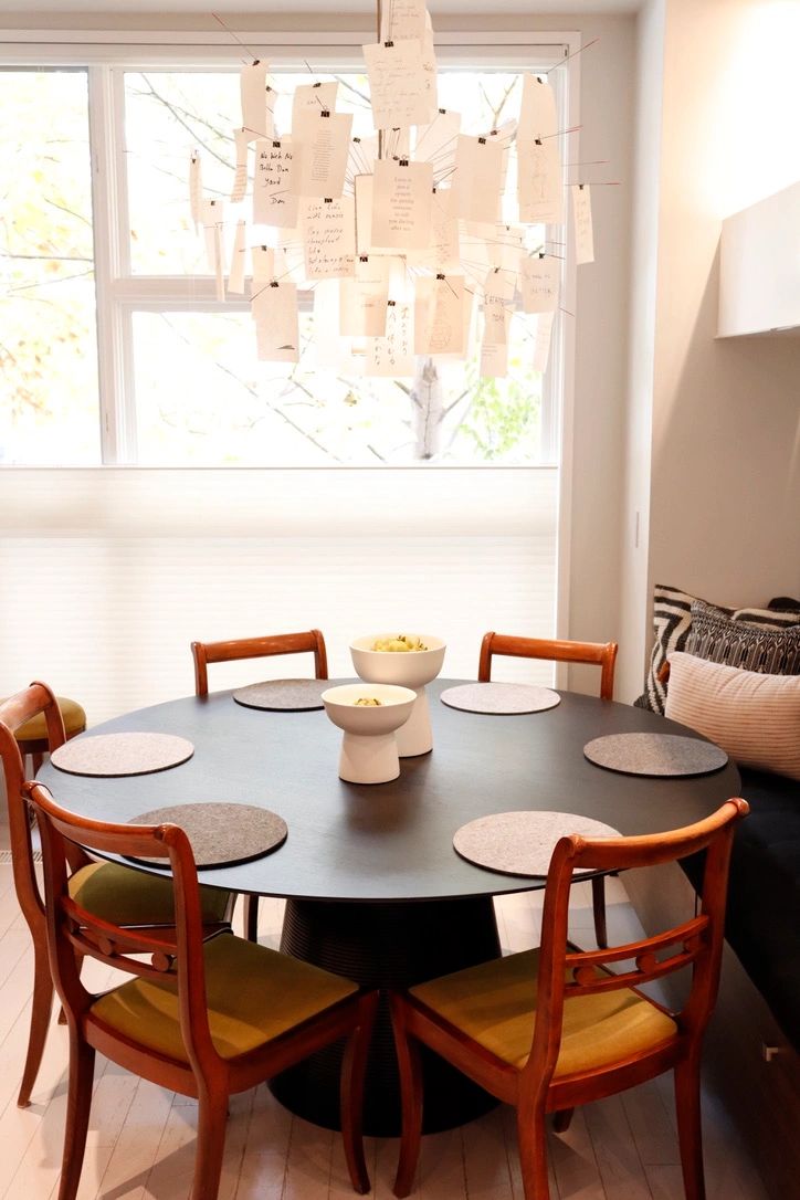 Modern dining table with unique hanging notes light fixture.