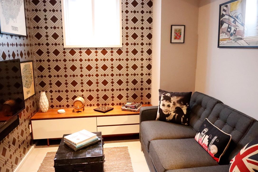 Cozy living room with patterned wallpaper and gray sofa.