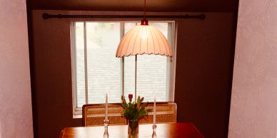 Cozy dining table with flower centerpiece and hanging lamp.
