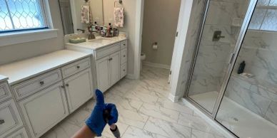 Person holding tool in modern bathroom.