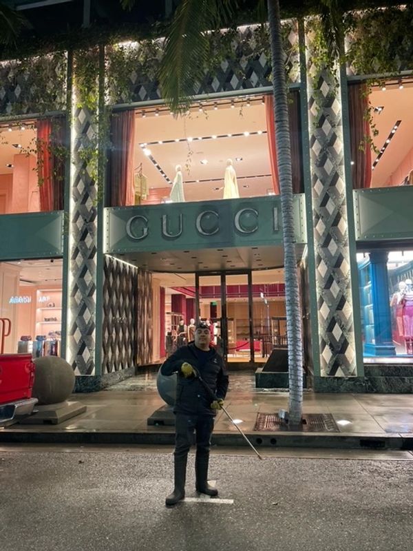 Person standing in front of a Gucci store at night.