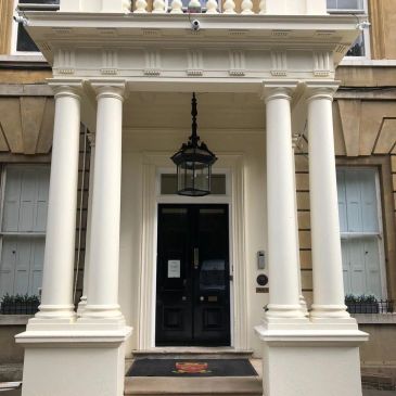 Columns and entrance of a building with a hanging lantern.