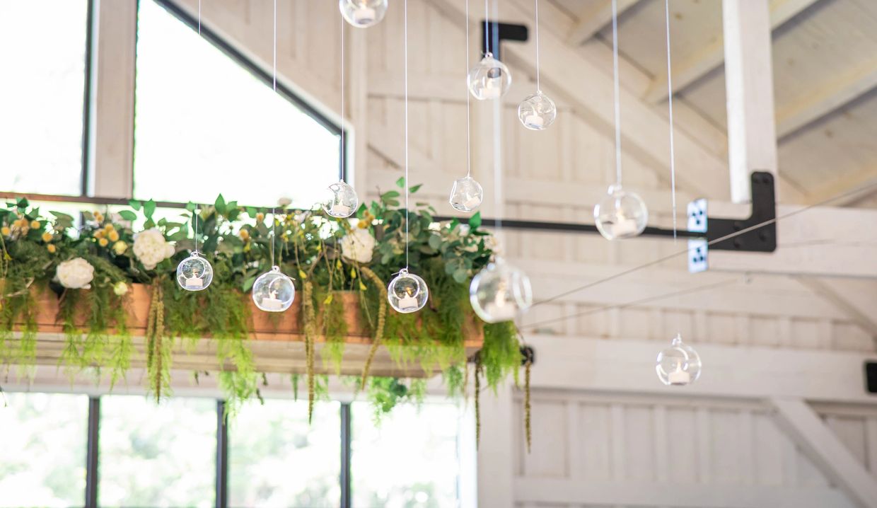 Ceiling installation with glass orbs and tea lights hanging over table at Meadows at Mossy Creek