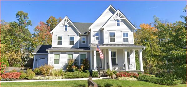 Large white house with a front porch and American flag.