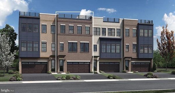 Modern three-story townhouses with brick and glass facades under a clear sky.