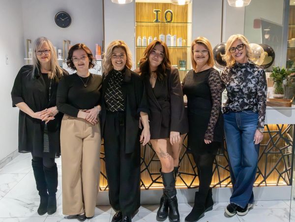 Groupe de six femmes souriantes en intérieur.