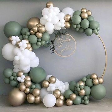 A green, white, and gold balloon arch