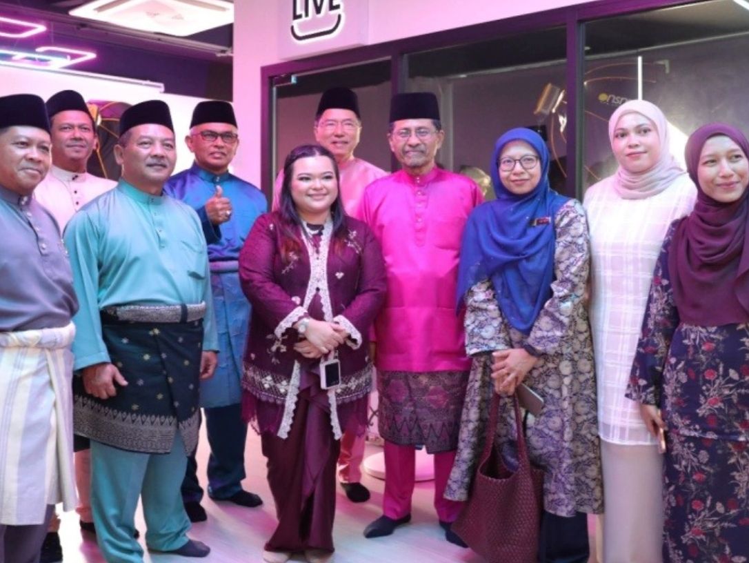 Group of people dressed in traditional attire posing indoors.