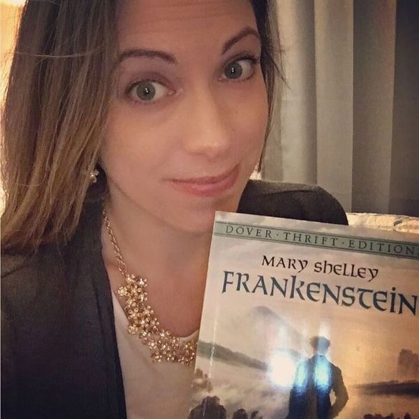 Woman holding a copy of Mary Shelley's Frankenstein book.