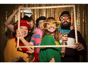 People having fun at a party using a photobooth rental 
