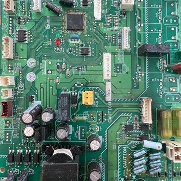 Close-up of a green printed circuit board with various electronic components.