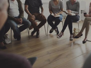 Group therapy session with participants seated in a circle.