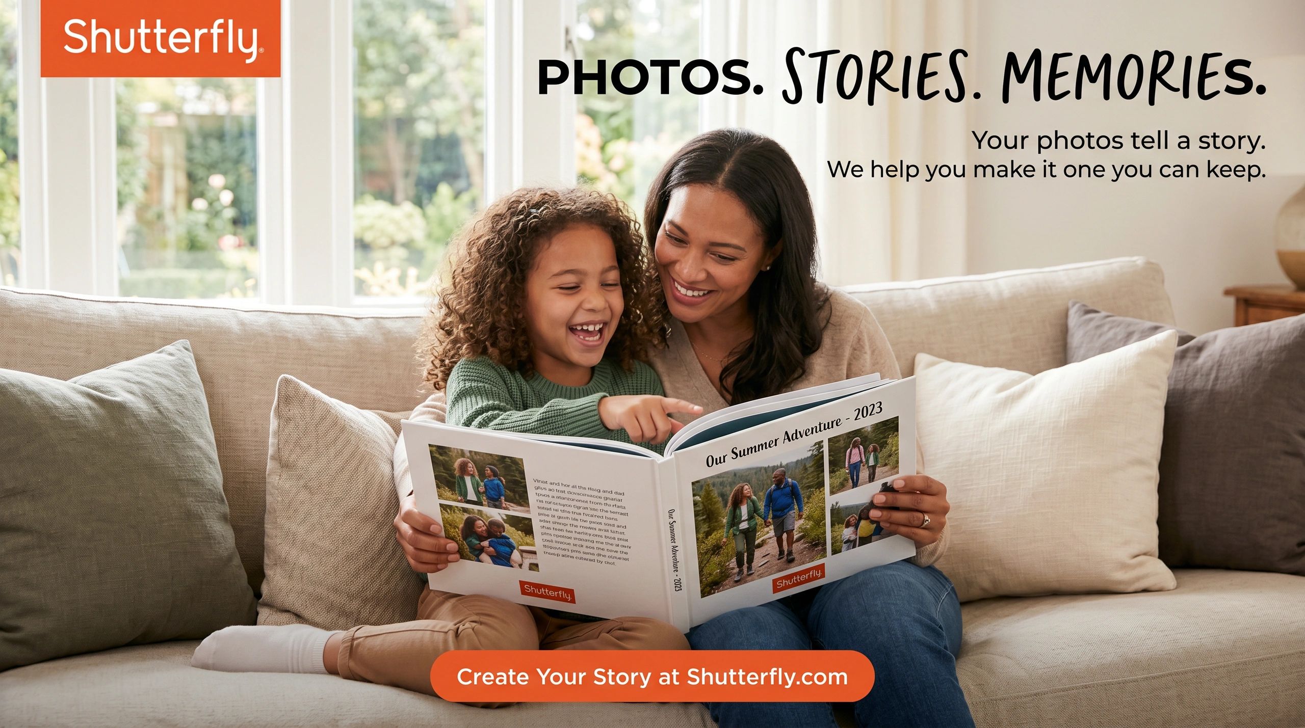 Mother and daughter joyfully looking at a photo book on a couch.