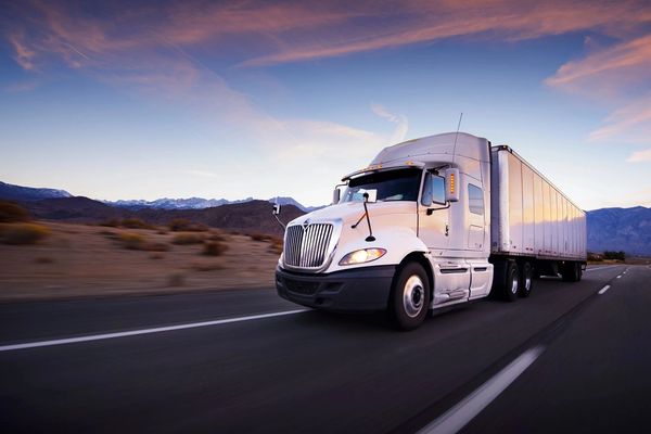 Truck and highway at sunset - transportation background