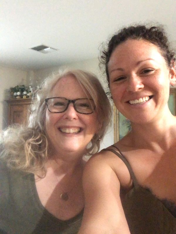 Two women smiling together indoors.